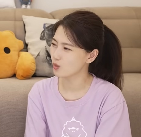 Source image for Woman in Purple Shirt Reacts with Skeptical Side Glance and Pursed Lips