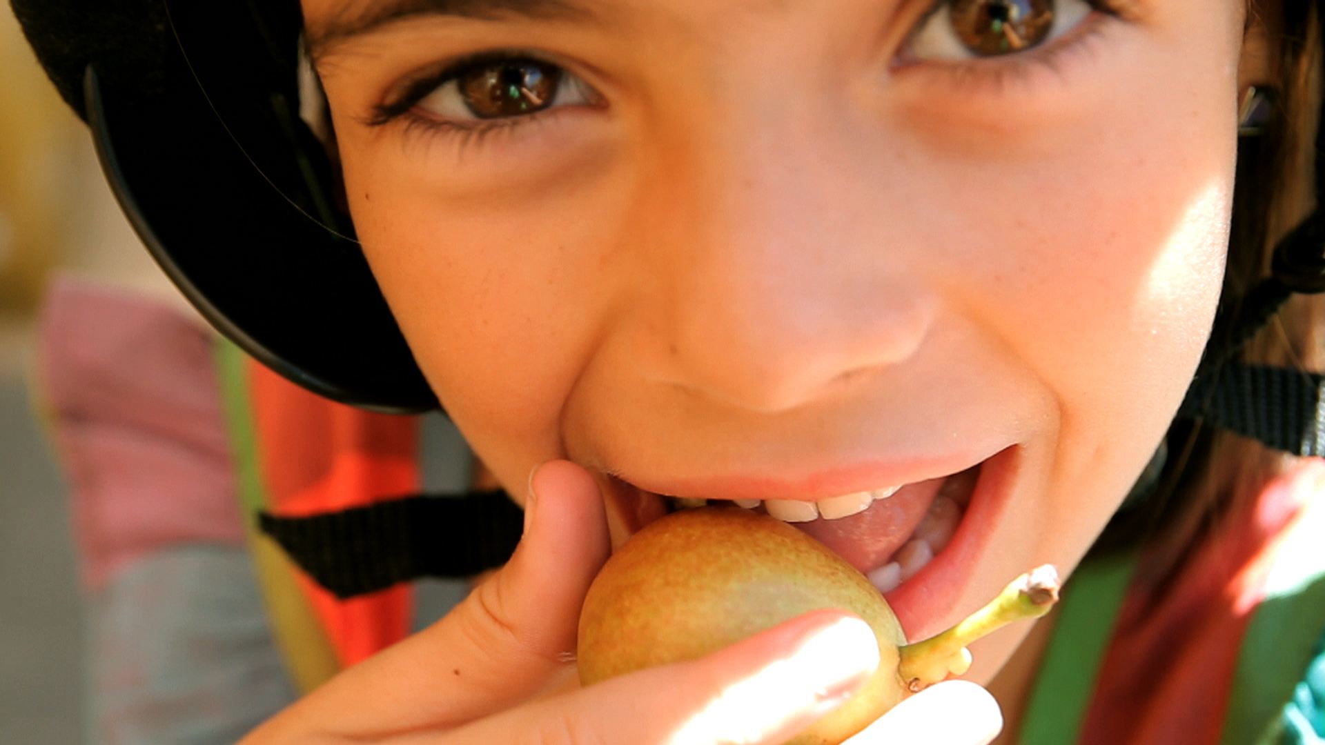 Source image for Child Bites into Small Pear with Excited Expression