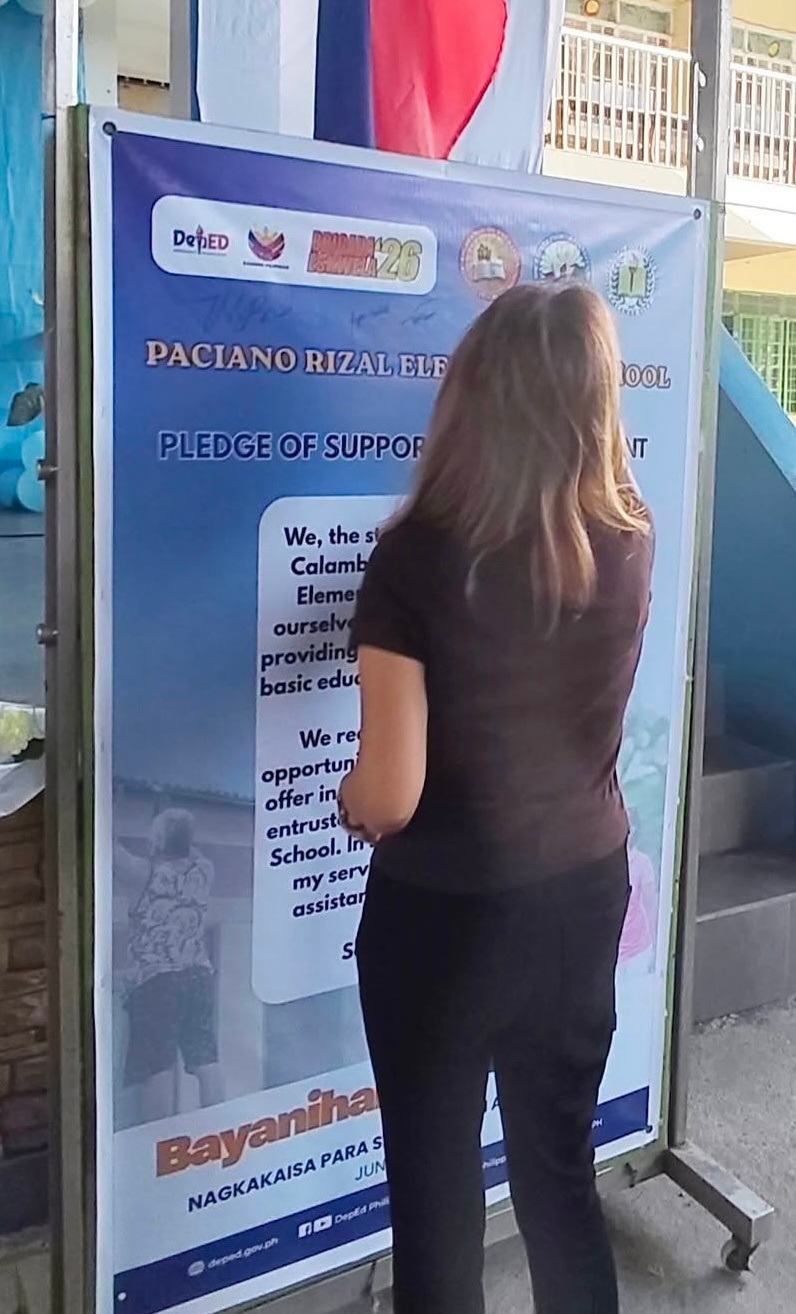 Source image for Woman Turns Around in Front of School Pledge Banner
