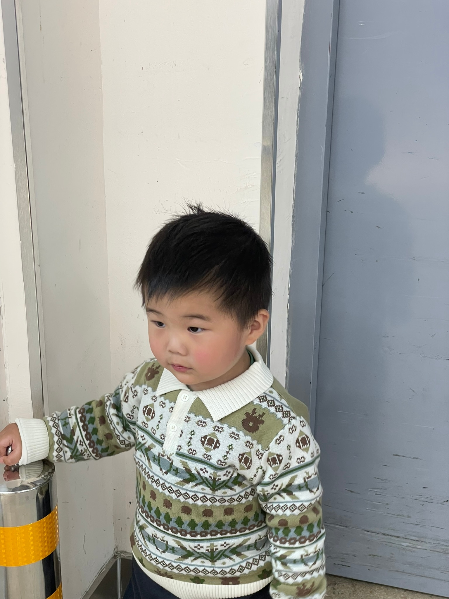 Source image for Toddler in Patterned Sweater Reacts to Something Off Camera