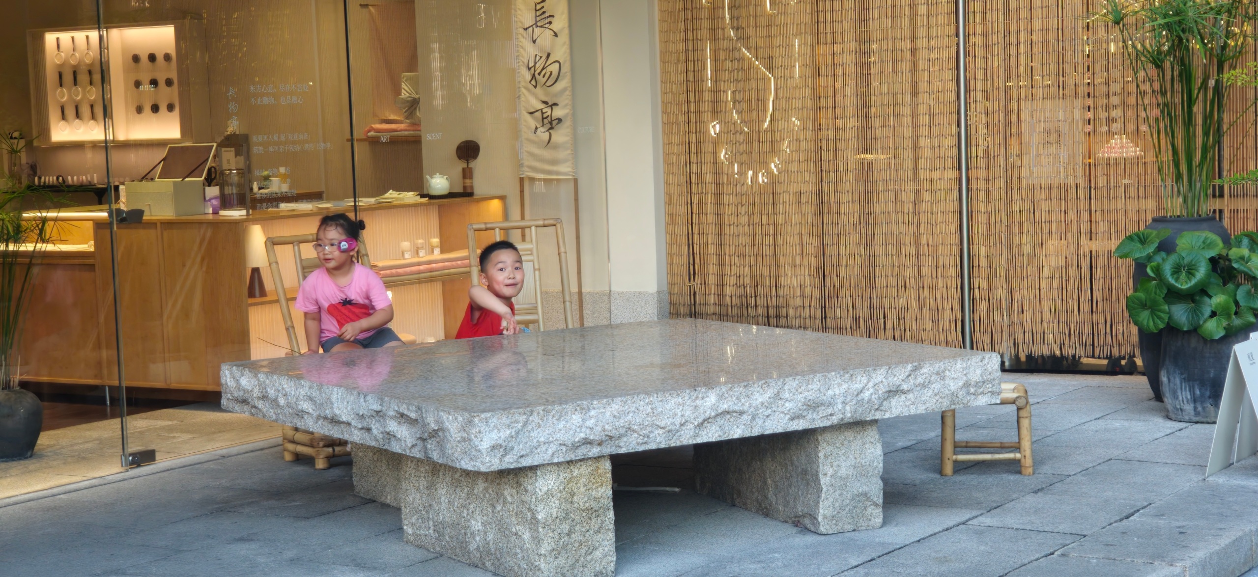 Source image for Two Kids Burst into Playful Chase Behind Stone Table