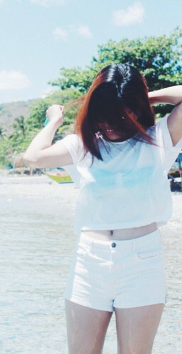 Source image for Woman Flips Hair Back to Reveal Surprised Expression on Sunny Beach