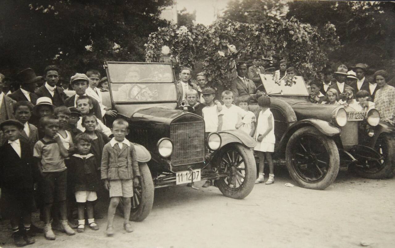 Source image for Crowd Gathers Around Historic 1920s Automobile for First Car Event