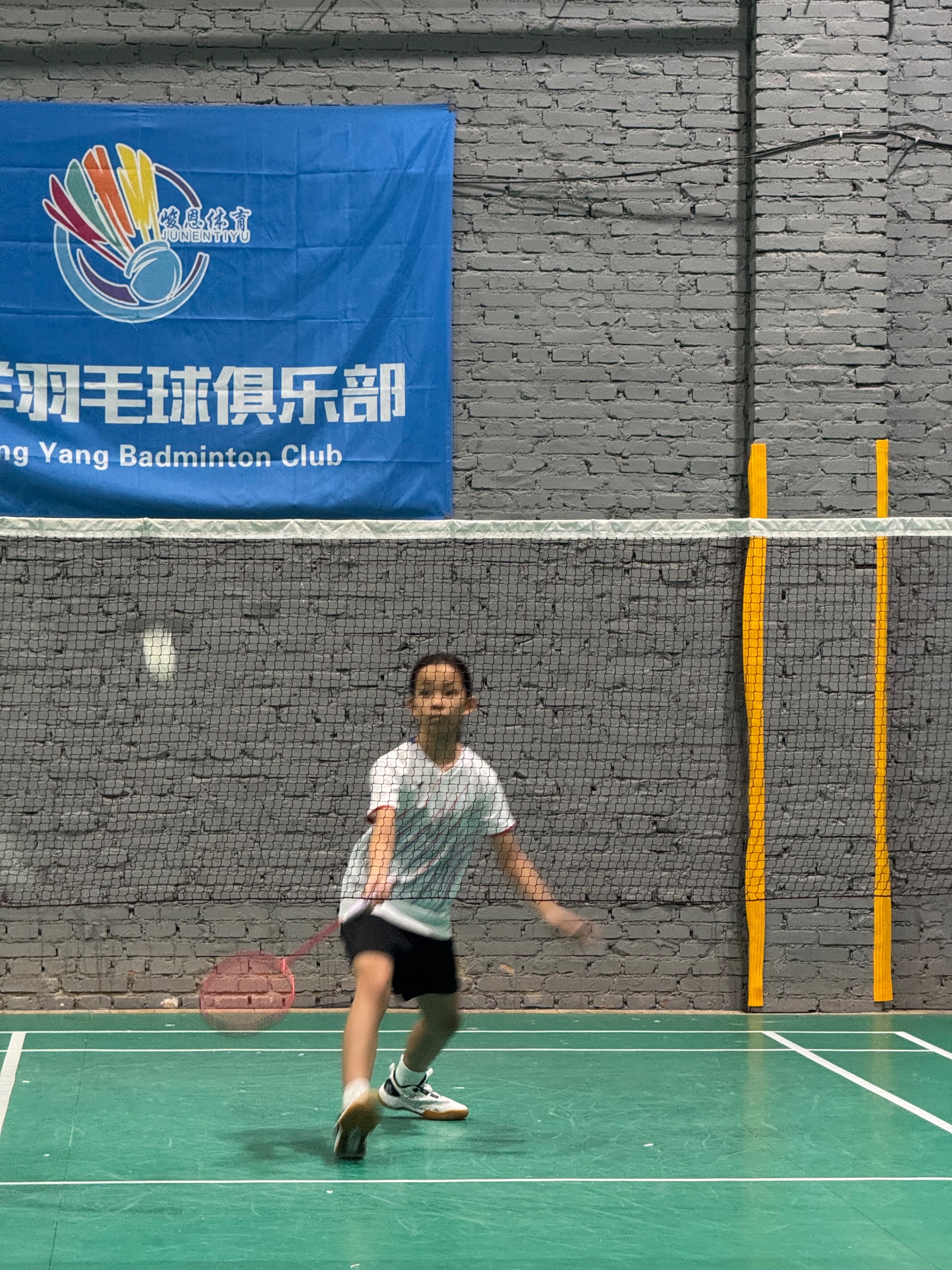 Source image for Young Badminton Player Swings Racket Through Net at Club